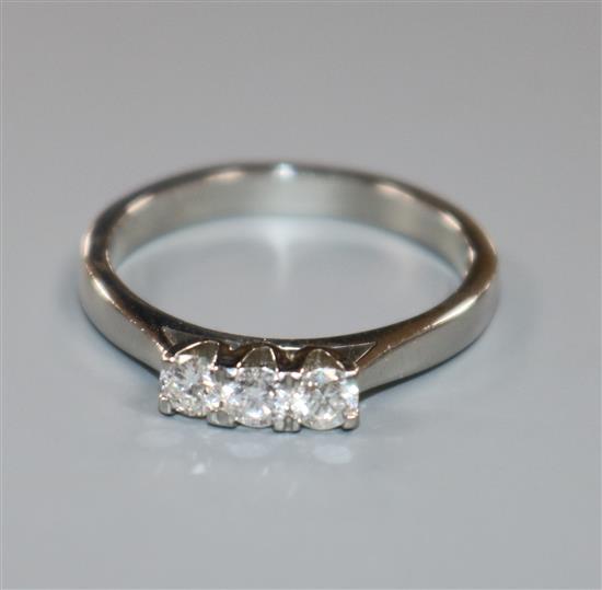 A modern platinum and three stone diamond ring, size N.